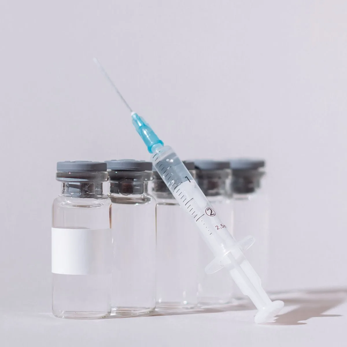 Gloved hand holding treatment vials — peptide therapy at Forever Glow Aesthetics & Wellness in Leander, TX